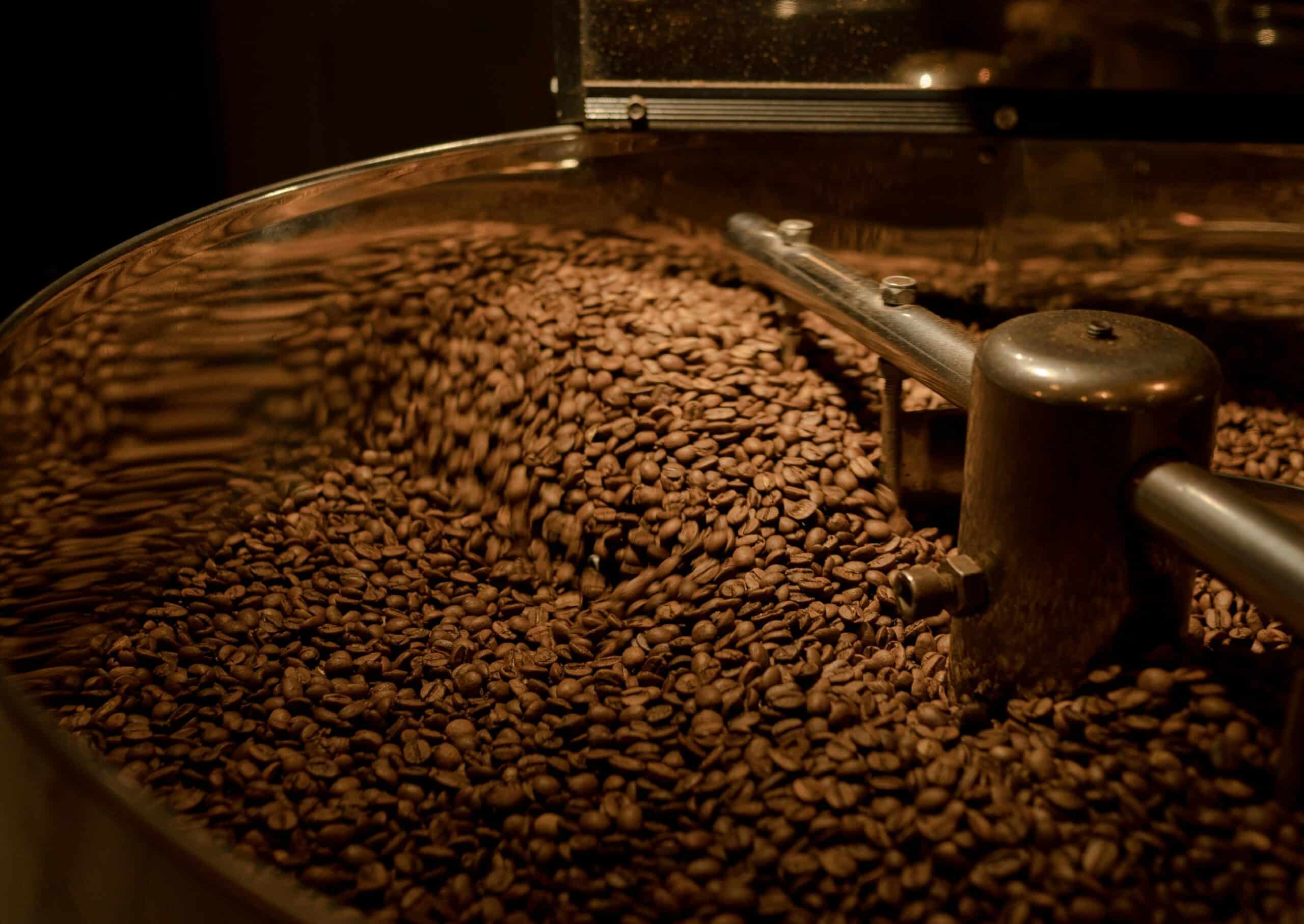 large commercial coffee roaster mixing roasted beans.